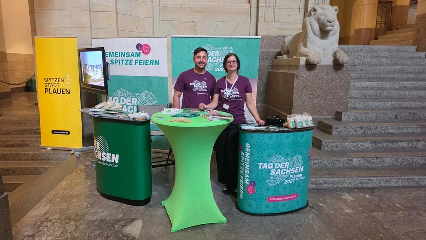 Zwei Menschen stehen an einem Informationsstand.