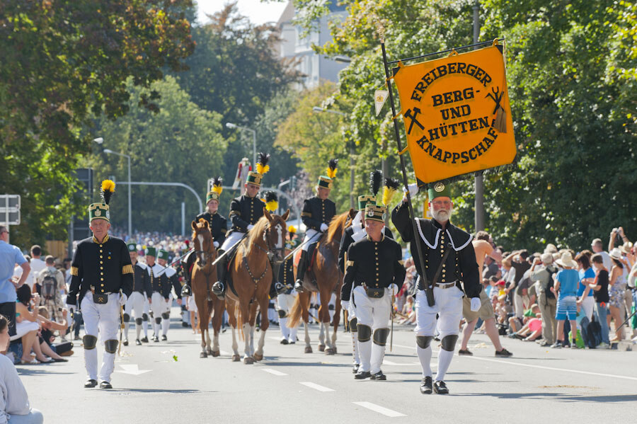 Eine Parade von Personen in traditionellen Bergmannsuniformen