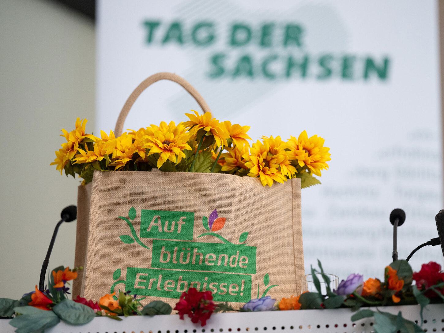 Eine Tasche, gefüllt mit Sebnitzer Seidenblumen und der Aufschrift »auf blühende Erlebnisse«