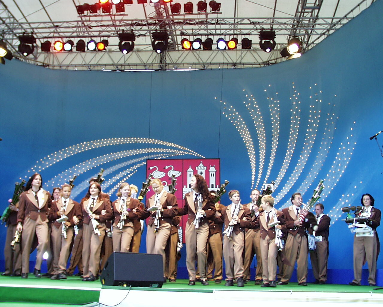 Musikgruppe mit Instrumenten auf großer, beleuchteter Festbühne