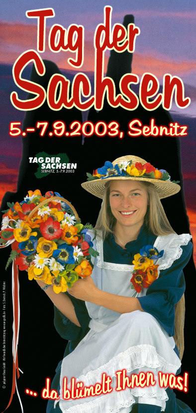 Werbeplakat für den Tag der Sachsen mit einer lächelnden jungen Frau in traditioneller Kleidung und Blumenschmuck
