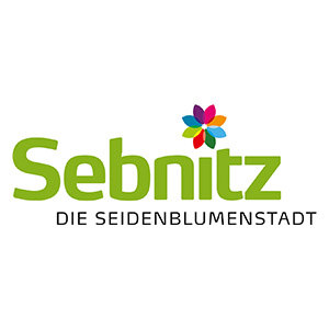 Das Logo der Stadt Sebnitz zeigt einen Schriftzug »Sebnitz«. Statt des I-Punktes ist eine stilisierte Blume ergänzt.